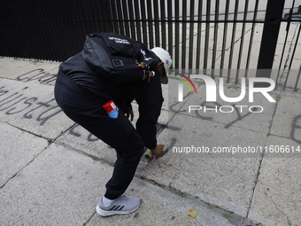 The 43 missing students of Ayotzinapa paint graffiti outside the Senate of the Republic in Mexico City, Mexico, on September 24, 2024, to de...