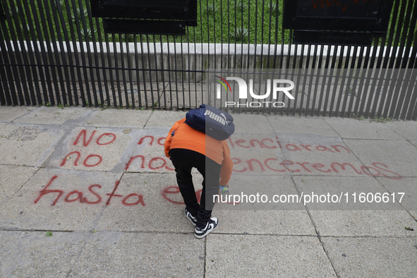 The 43 missing students of Ayotzinapa paint graffiti outside the Senate of the Republic in Mexico City, Mexico, on September 24, 2024, to de...