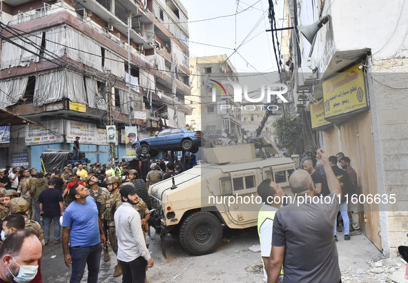 Security forces and medical teams arrive in the area after the Israeli army targets the 4th and 5th floors of a building in the Ghobeiry mun...