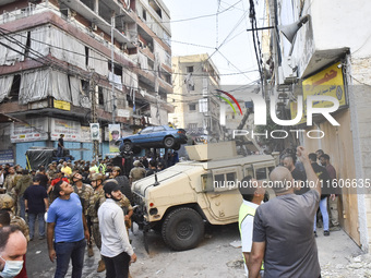 Security forces and medical teams arrive in the area after the Israeli army targets the 4th and 5th floors of a building in the Ghobeiry mun...