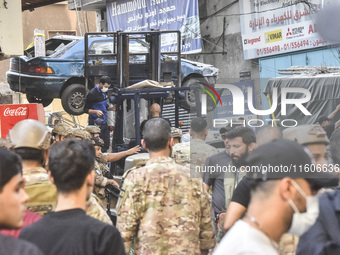 Security forces and medical teams arrive in the area after the Israeli army targets the 4th and 5th floors of a building in the Ghobeiry mun...