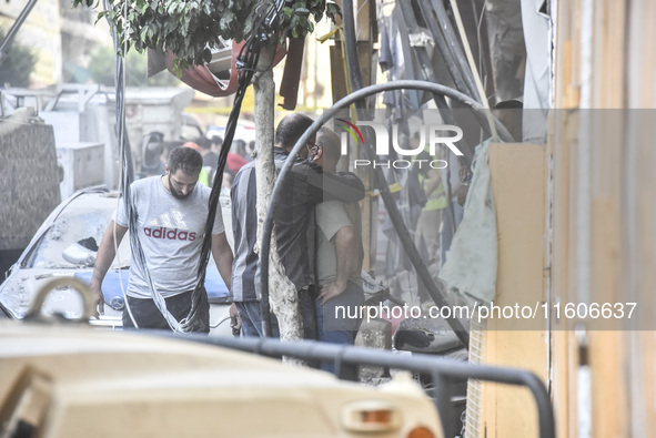 Security forces and medical teams arrive in the area after the Israeli army targets the 4th and 5th floors of a building in the Ghobeiry mun...