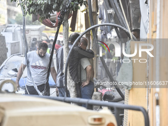 Security forces and medical teams arrive in the area after the Israeli army targets the 4th and 5th floors of a building in the Ghobeiry mun...