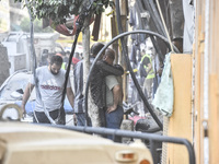 Security forces and medical teams arrive in the area after the Israeli army targets the 4th and 5th floors of a building in the Ghobeiry mun...