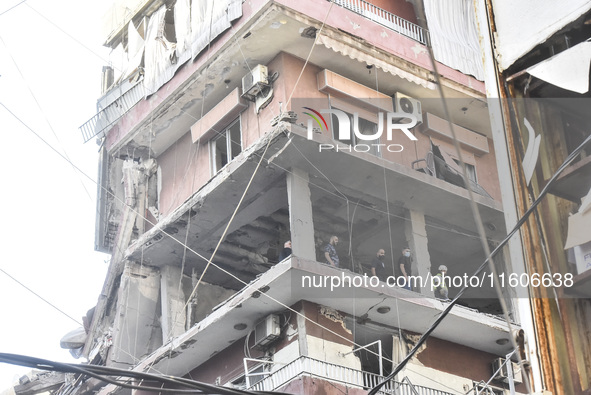 Security forces and medical teams arrive in the area after the Israeli army targets the 4th and 5th floors of a building in the Ghobeiry mun...