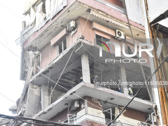 Security forces and medical teams arrive in the area after the Israeli army targets the 4th and 5th floors of a building in the Ghobeiry mun...