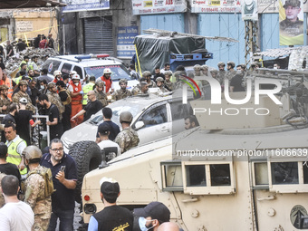 Security forces and medical teams arrive in the area after the Israeli army targets the 4th and 5th floors of a building in the Ghobeiry mun...