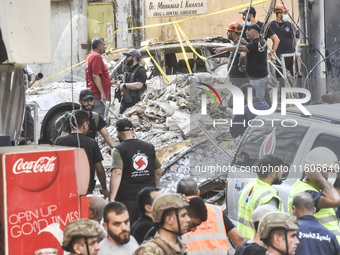 Security forces and medical teams arrive in the area after the Israeli army targets the 4th and 5th floors of a building in the Ghobeiry mun...