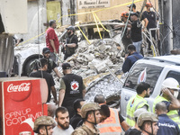 Security forces and medical teams arrive in the area after the Israeli army targets the 4th and 5th floors of a building in the Ghobeiry mun...