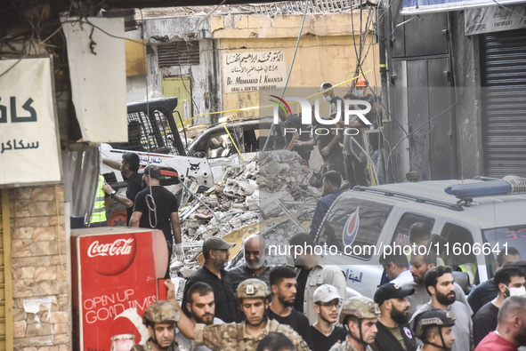 Security forces and medical teams arrive in the area after the Israeli army targets the 4th and 5th floors of a building in the Ghobeiry mun...