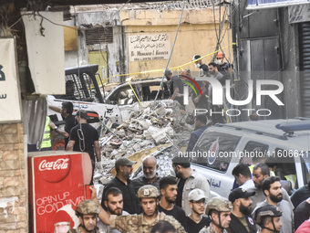 Security forces and medical teams arrive in the area after the Israeli army targets the 4th and 5th floors of a building in the Ghobeiry mun...