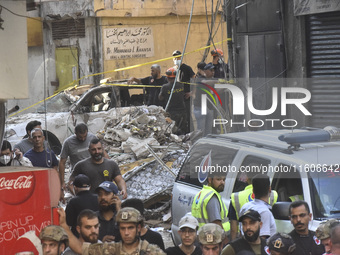 Security forces and medical teams arrive in the area after the Israeli army targets the 4th and 5th floors of a building in the Ghobeiry mun...