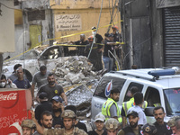 Security forces and medical teams arrive in the area after the Israeli army targets the 4th and 5th floors of a building in the Ghobeiry mun...