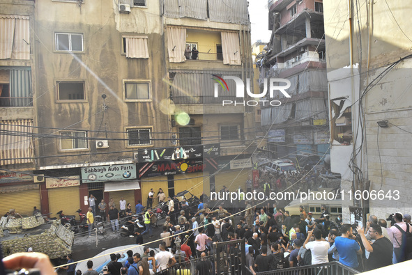 Security forces and medical teams arrive in the area after the Israeli army targets the 4th and 5th floors of a building in the Ghobeiry mun...