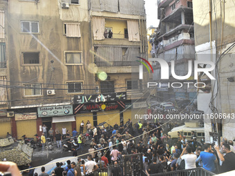 Security forces and medical teams arrive in the area after the Israeli army targets the 4th and 5th floors of a building in the Ghobeiry mun...