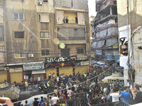 Security forces and medical teams arrive in the area after the Israeli army targets the 4th and 5th floors of a building in the Ghobeiry mun...