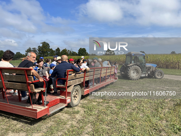 People take a tractor wagon ride to an apple orchard in Stouffville, Ontario, Canada, on September 22, 2024. 