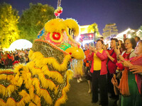 Tourists watch a lion dance performance at the ancient town of Xunxian in Hebi, China, on September 24, 2024. (