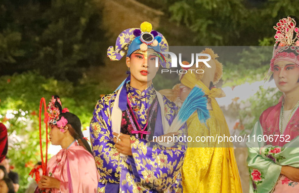 A stilt performer prepares to perform for tourists at the ancient town of Xunxian in Hebi, China, on September 24, 2024. 