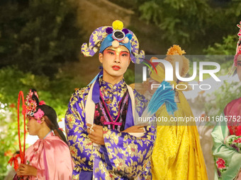 A stilt performer prepares to perform for tourists at the ancient town of Xunxian in Hebi, China, on September 24, 2024. (