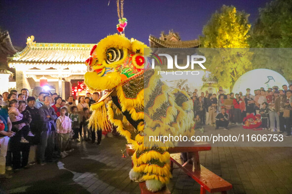 Actors perform a lion dance for tourists at the ancient town of Xunxian in Hebi, China, on September 24, 2024. 