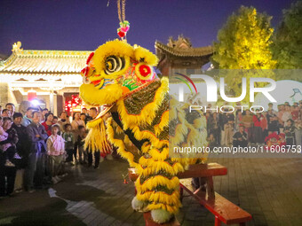 Actors perform a lion dance for tourists at the ancient town of Xunxian in Hebi, China, on September 24, 2024. (