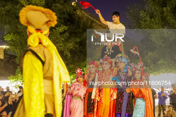 Stilt performers perform for tourists at the ancient town of Xunxian County in Hebi, China, on September 24, 2024. 