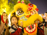 Children pose for a photo with lion dancers at the ancient town of Xunxian in Hebi, China, on September 24, 2024. (