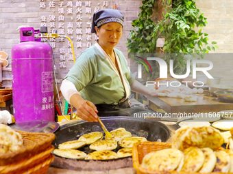 A stall in the ancient town of Xunxian County prepares local snacks for tourists in Hebi, China, on September 24, 2024. (