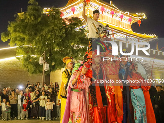 Stilt performers perform for tourists at the ancient town of Xunxian County in Hebi, China, on September 24, 2024. (