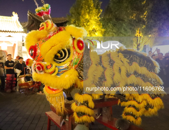 Actors perform a lion dance for tourists at the ancient town of Xunxian in Hebi, China, on September 24, 2024. 