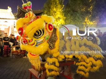 Actors perform a lion dance for tourists at the ancient town of Xunxian in Hebi, China, on September 24, 2024. (