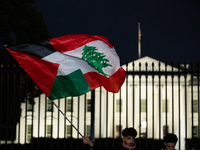 People fly a half Palestinian and half Lebanese flag during a pro-Lebanon demonstration in front of the White House following extensive air...