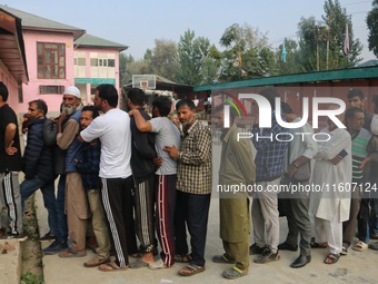 Voters queue to cast their ballots at a polling station during the second phase of assembly elections in Srinagar, Jammu and Kashmir, on Sep...