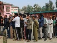 Voters queue to cast their ballots at a polling station during the second phase of assembly elections in Srinagar, Jammu and Kashmir, on Sep...