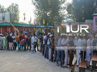 Voters queue to cast their ballots at a polling station during the second phase of assembly elections in Srinagar, Jammu and Kashmir, on Sep...