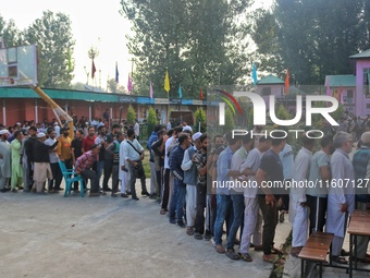 Voters queue to cast their ballots at a polling station during the second phase of assembly elections in Srinagar, Jammu and Kashmir, on Sep...