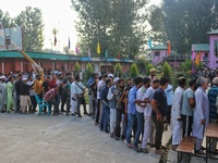 Voters queue to cast their ballots at a polling station during the second phase of assembly elections in Srinagar, Jammu and Kashmir, on Sep...