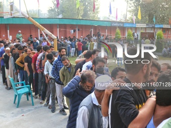 Voters queue to cast their ballots at a polling station during the second phase of assembly elections in Srinagar, Jammu and Kashmir, on Sep...