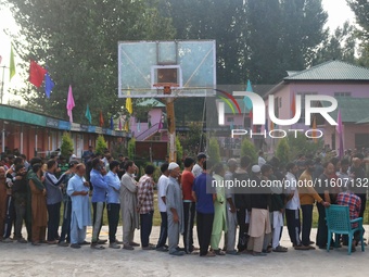 Voters queue to cast their ballots at a polling station during the second phase of assembly elections in Srinagar, Jammu and Kashmir, on Sep...