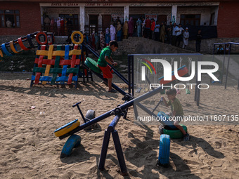 Kids play as people wait to cast their votes in the second phase of Assembly elections in Beerwah, Jammu and Kashmir, India, on September 25...