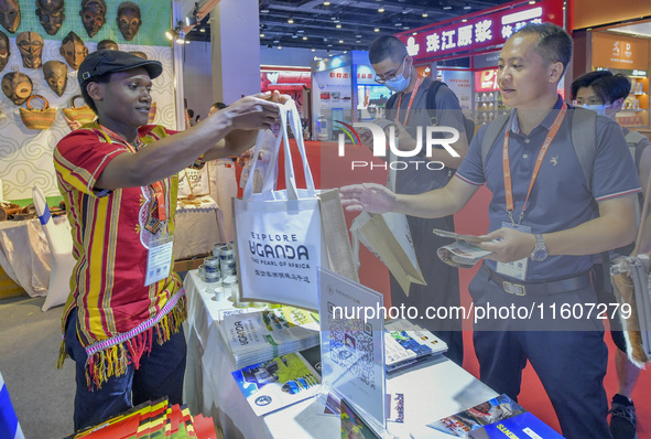 Visitors buy cultural and creative goods at the Ugandan stand at the 21st China-Asean Expo in Nanning, Guangxi Zhuang Autonomous Region, Chi...