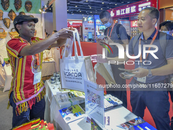 Visitors buy cultural and creative goods at the Ugandan stand at the 21st China-Asean Expo in Nanning, Guangxi Zhuang Autonomous Region, Chi...