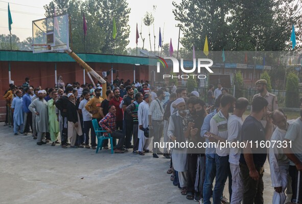 Voters queue to cast their ballots at a polling station during the second phase of assembly elections in Srinagar, Jammu and Kashmir, on Sep...