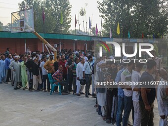 Voters queue to cast their ballots at a polling station during the second phase of assembly elections in Srinagar, Jammu and Kashmir, on Sep...