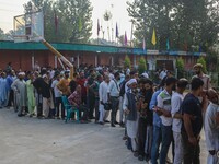 Voters queue to cast their ballots at a polling station during the second phase of assembly elections in Srinagar, Jammu and Kashmir, on Sep...