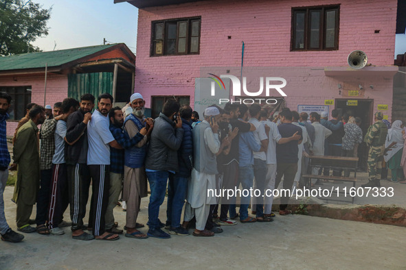 Voters queue to cast their ballots at a polling station during the second phase of assembly elections in Srinagar, Jammu and Kashmir, on Sep...