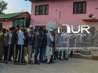 Voters queue to cast their ballots at a polling station during the second phase of assembly elections in Srinagar, Jammu and Kashmir, on Sep...