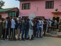 Voters queue to cast their ballots at a polling station during the second phase of assembly elections in Srinagar, Jammu and Kashmir, on Sep...