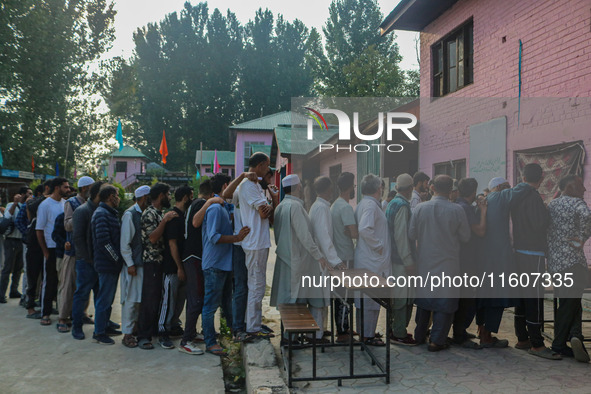 Voters queue to cast their ballots at a polling station during the second phase of assembly elections in Srinagar, Jammu and Kashmir, on Sep...